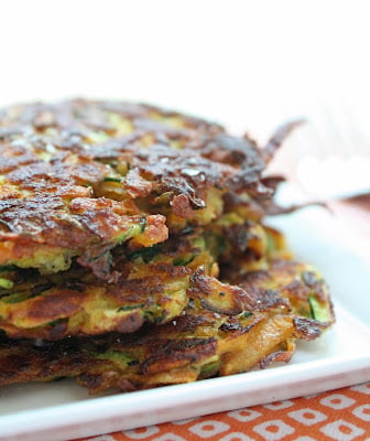 Front view of keto zucchini latkes on a square white plate