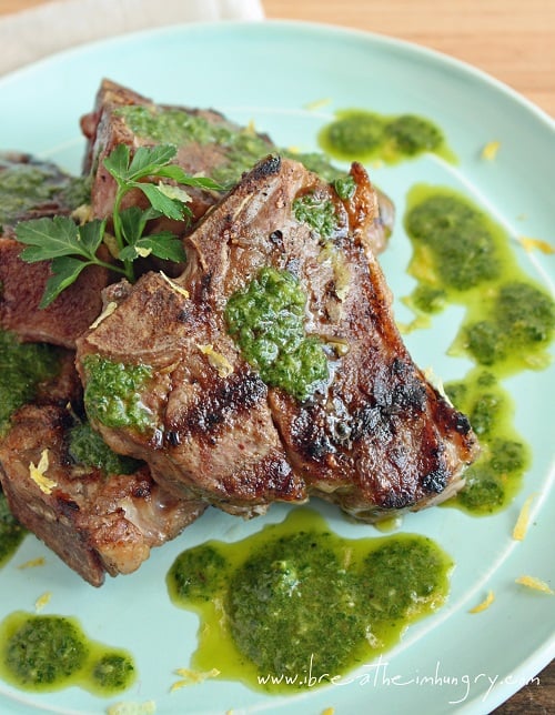grilled lamb with charmoula sauce on a teal plate