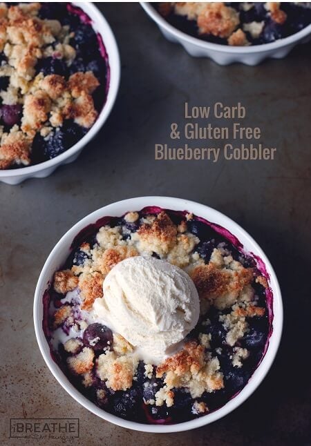 keto blueberry cobbler with shortbread crust and vanilla ice cream in a white bowl