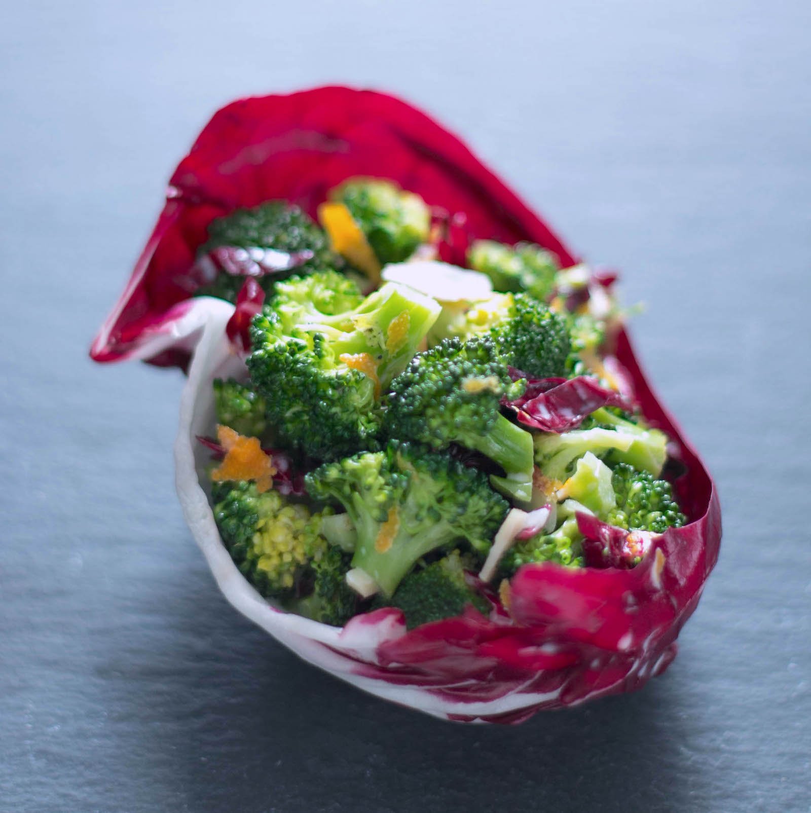 keto broccoli salad served in a radicchio leaf on a slate board