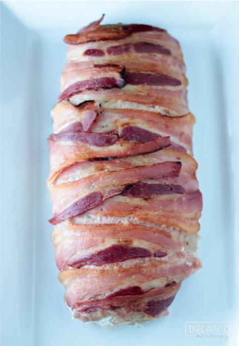 A tasty pork meatloaf stuffed with jalapeño popper filling and wrapped with bacon