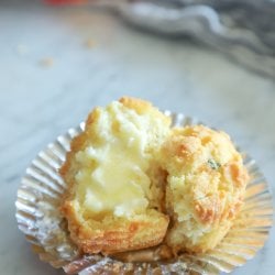 Keto Cheesy Herb Muffin cut in half and slathered in butter