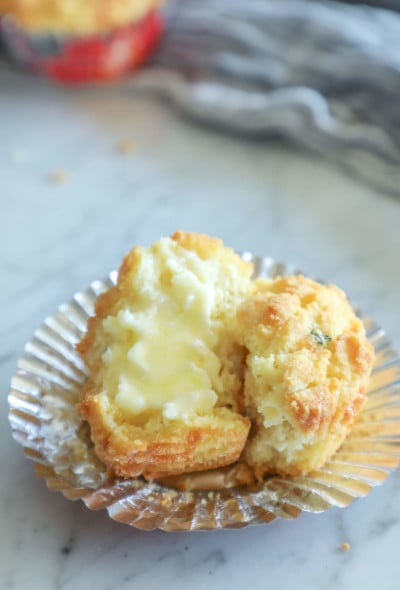 Keto Cheesy Herb Muffin cut in half and slathered in butter