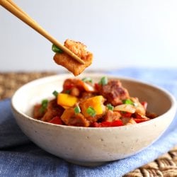 Keto Sweet & Sour Pork in a pottery bowl with chopsticks