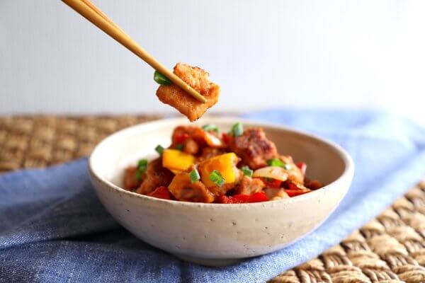 Keto Sweet & Sour Pork in a pottery bowl with chopsticks 