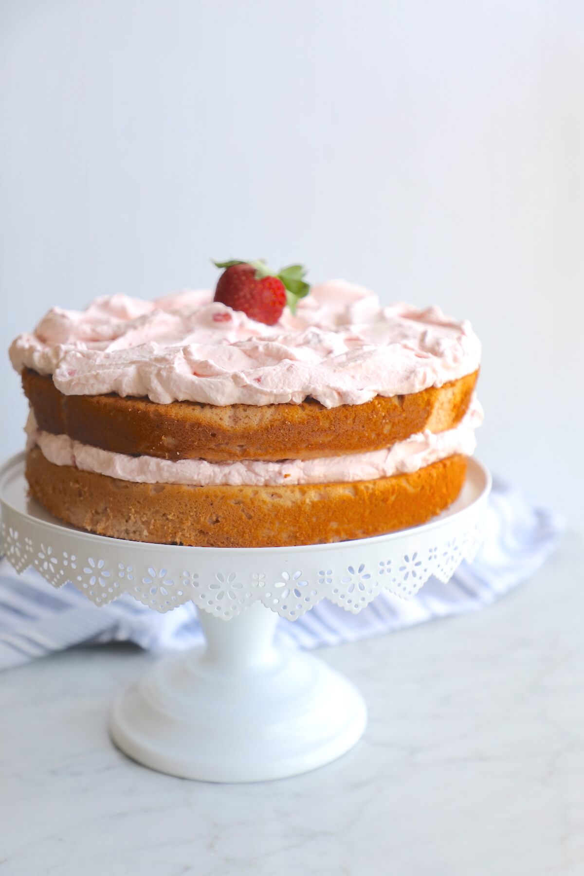Keto Strawberry Mousse Cake on a white cake pedestal 