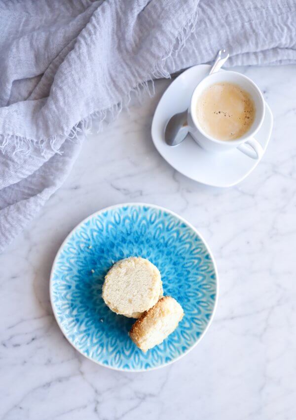 keto coconut shortbread cookies on a blue plate with a white espresso in the background