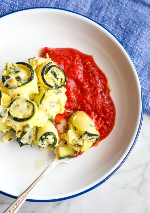 Keto Zucchini Rollatini on a white plate with a blue rim top view