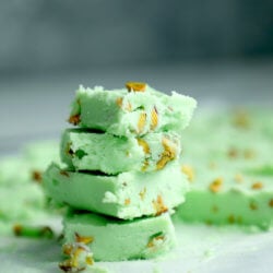 Keto Pistachio Fudge pieces stacked on a marble board