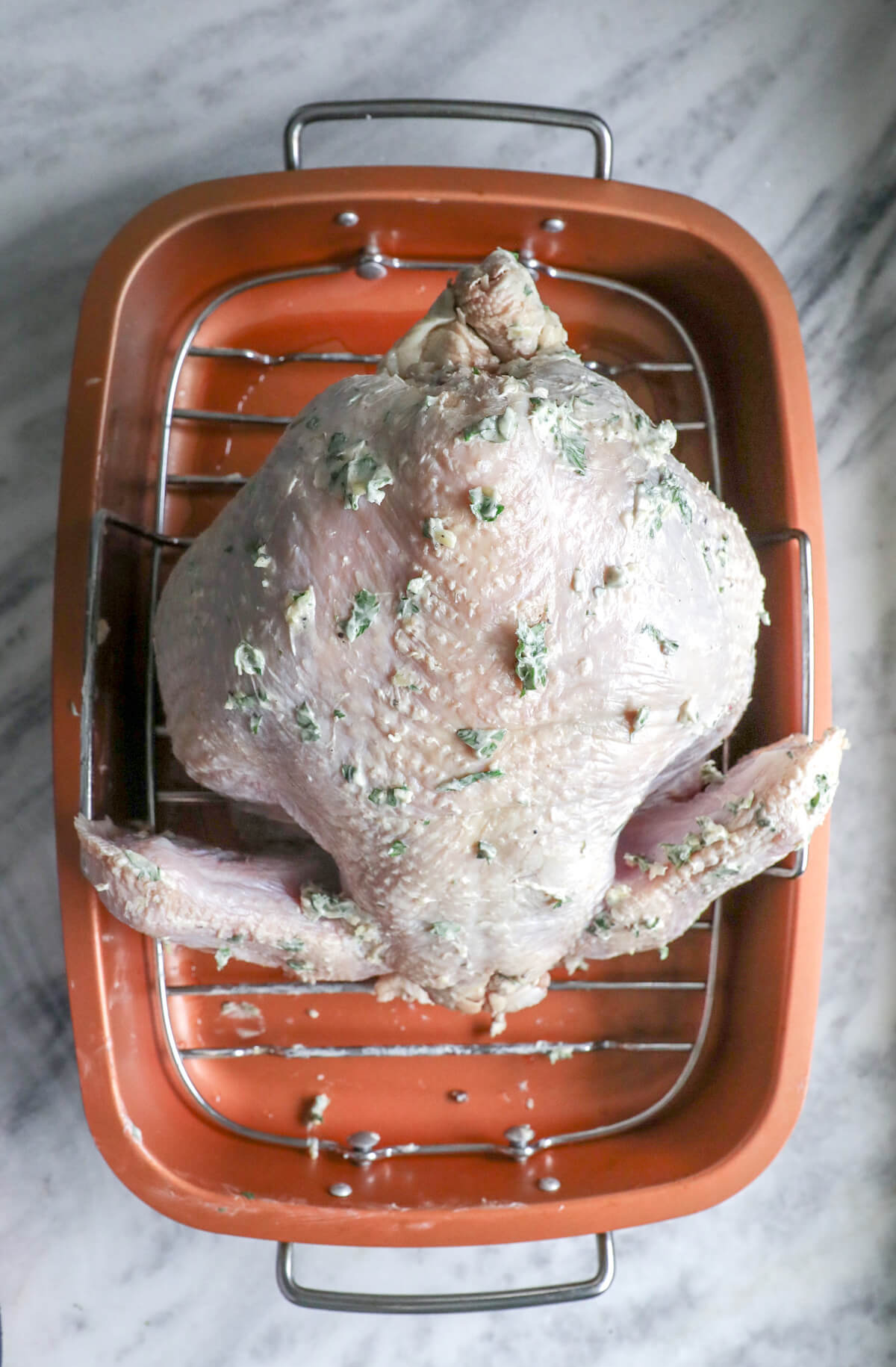 Easy Keto Roasted Turkey raw and upside down in a copper roasting pan