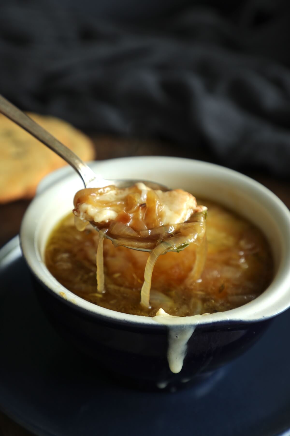 Spoonful of Keto French Onion Soup dripping with onions and cheese
