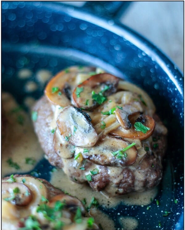 Keto Salisbury steak with mushroom gravy on a blue enamelware plate