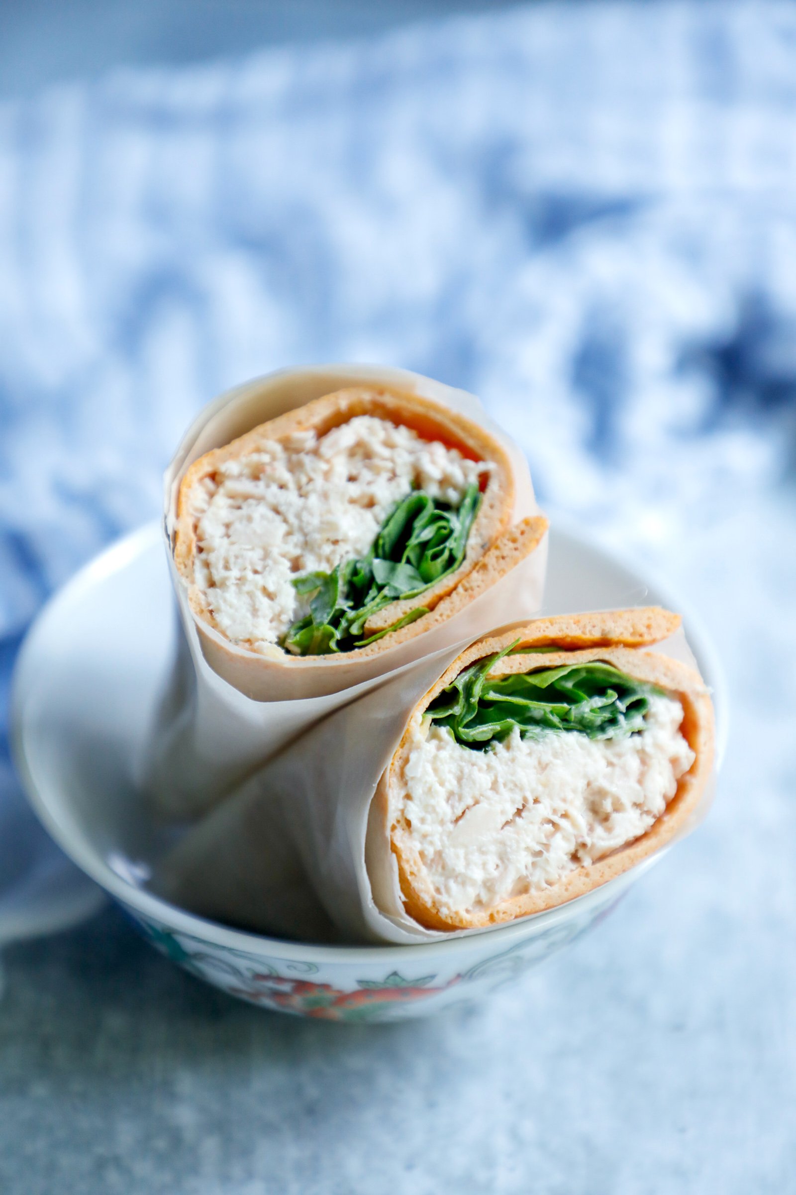 Keto Sandwich wrap used to make a tuna salad wrap with arugula and wrapped in parchment paper to hold it all together.