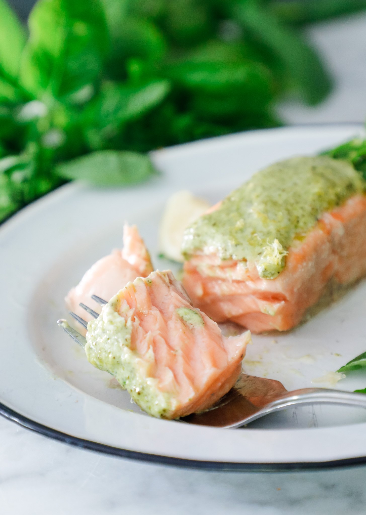 A forkful of air fryer salmon with basil pesto on it.
